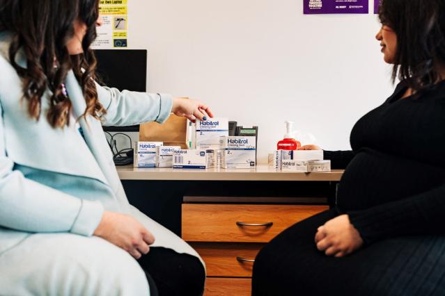 Two women looking at a few boxes of nicotine gum