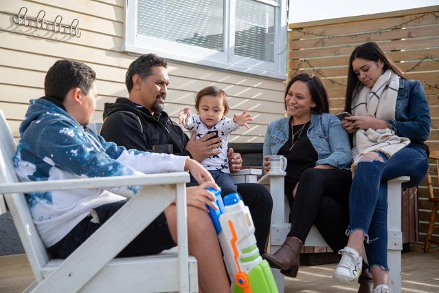 Family of five gathering together on a porch